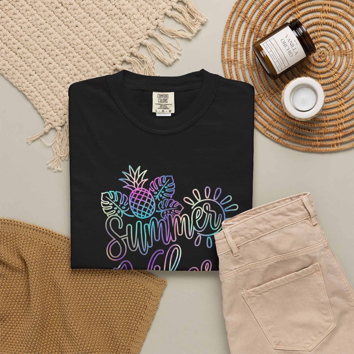 Black sweatshirt with colorful 'Summer vibes' design on a neutral surface with accessories.