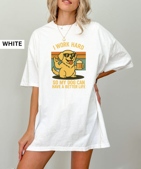 Person wearing a white t-shirt with a graphic of a dog and text that says "i work hard so my dog can have a better life, set indoors.