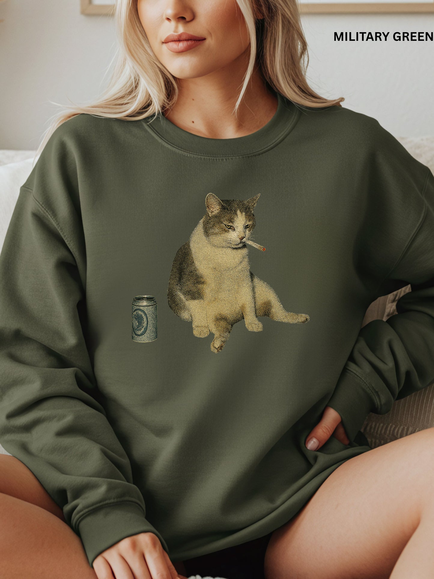 Person wearing a military green sweatshirt with a cat graphic and beer design.