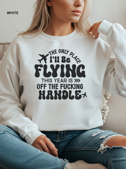 Person wearing a white sweatshirt with a humorous text design that says "the only place ill be flying is off the fucking handle, sitting on a couch.