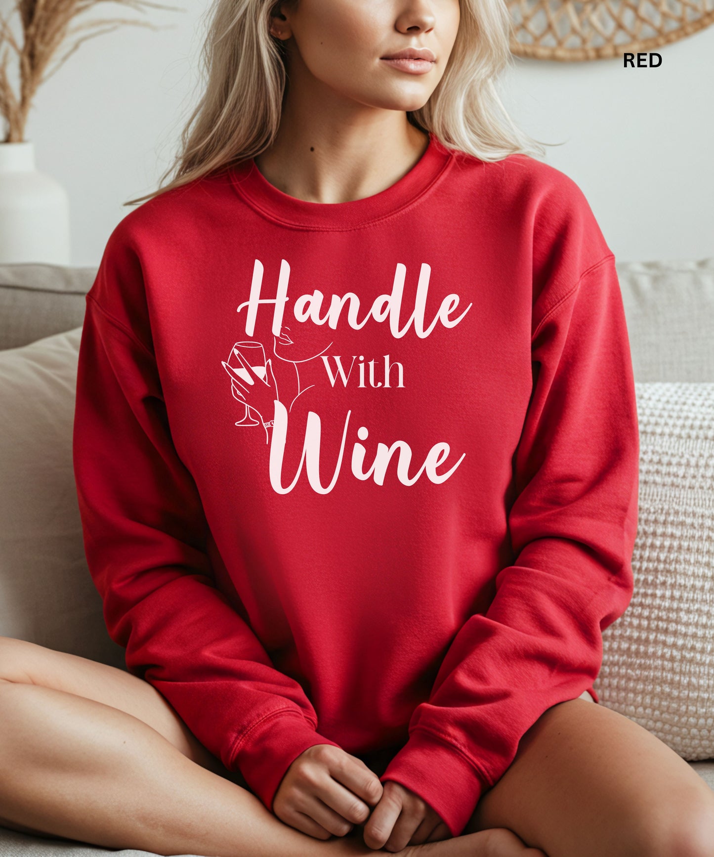 Person wearing a red sweatshirt with 'Handle With Wine' text and wine glass graphic.