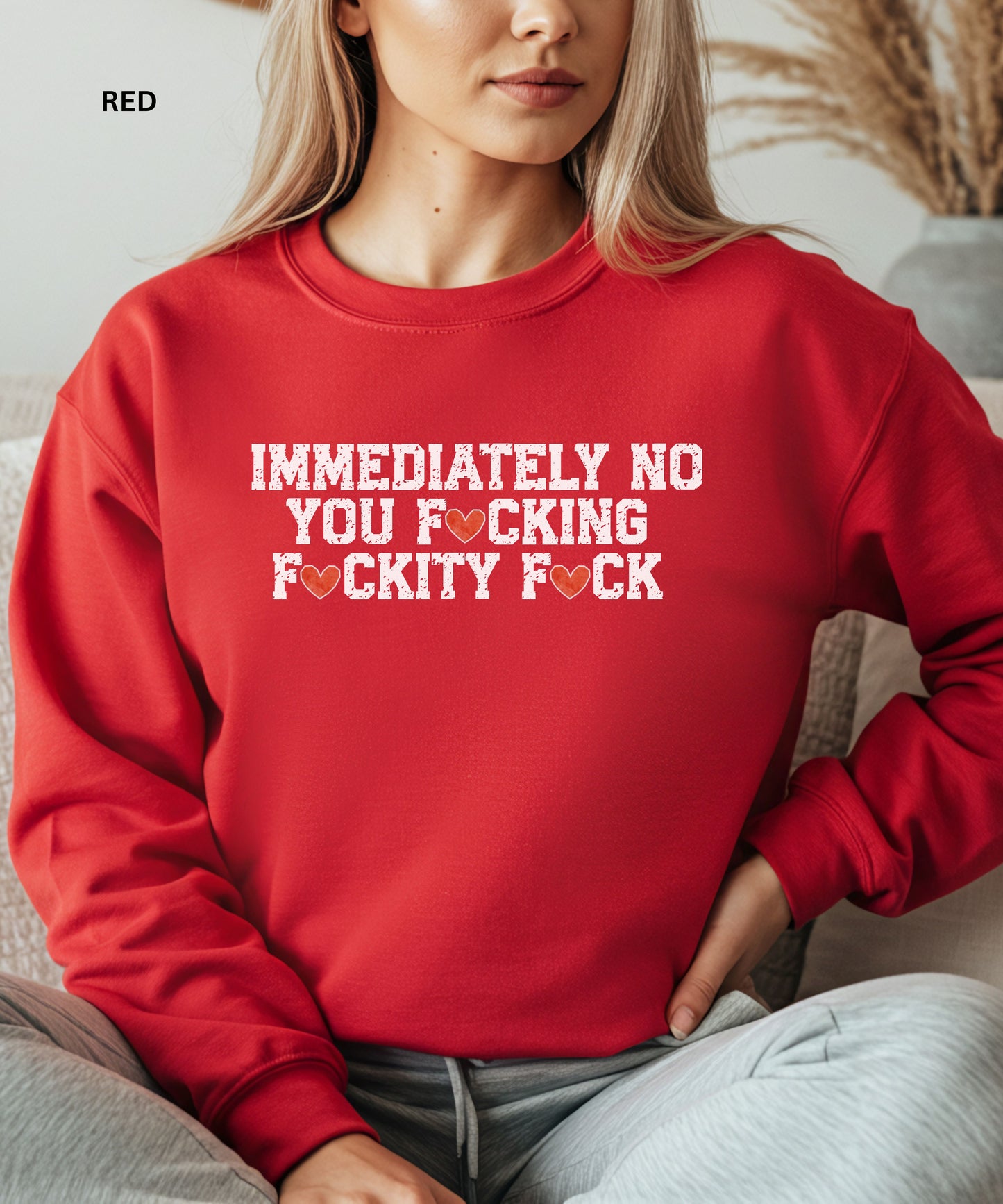 Person wearing a red sweatshirt with graphic text design.