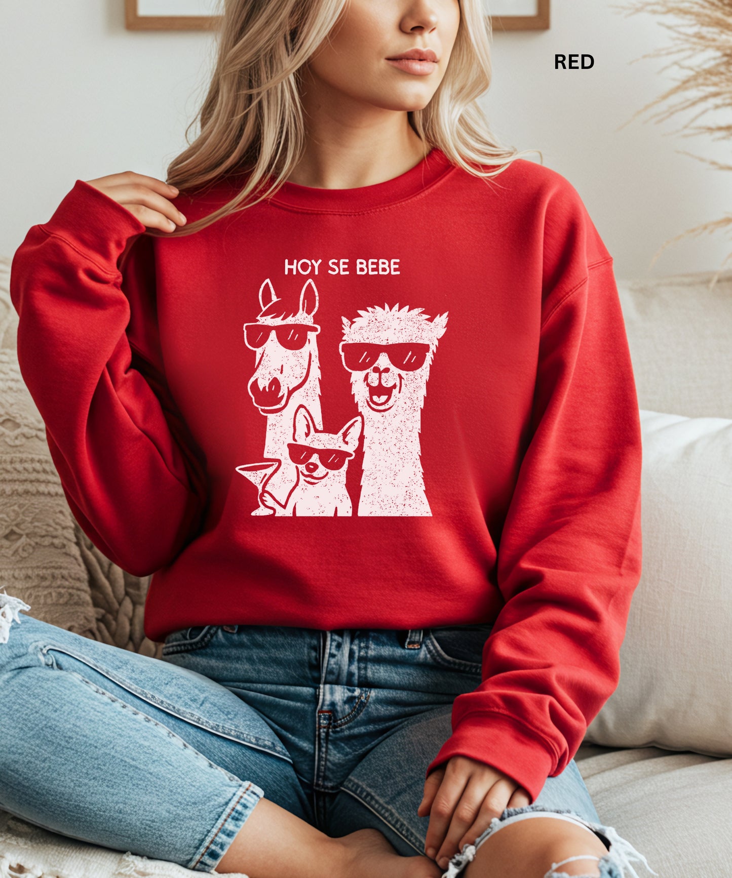 Person wearing a red sweatshirt with llama and dog graphic and 'HOY SE BEBE' text.