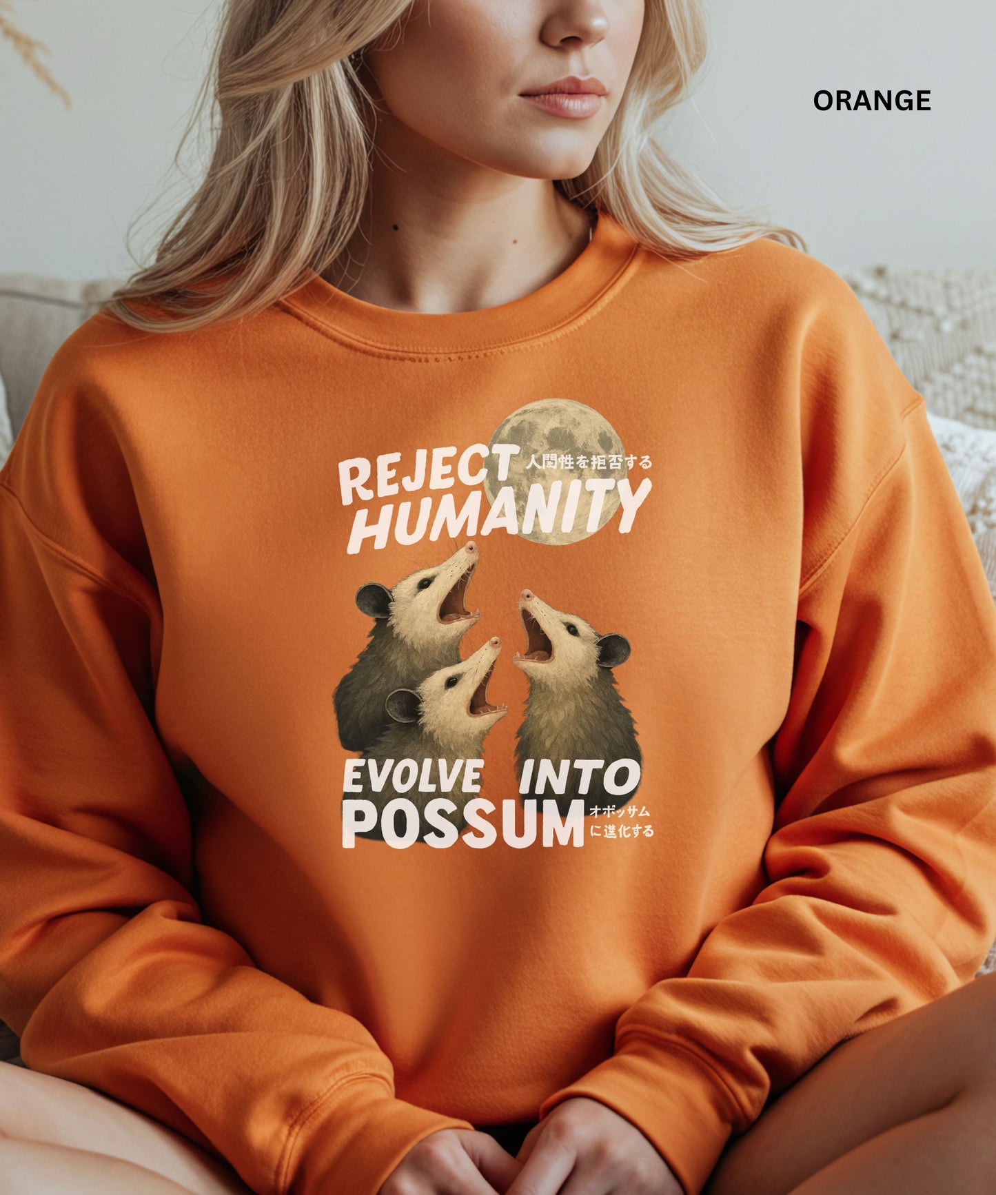 Person wearing an orange colored sweatshirt with a graphic design that says "reject humanity evolve into possum" sitting on a couch.