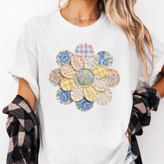 White t-shirt with a colorful floral design worn by a person.