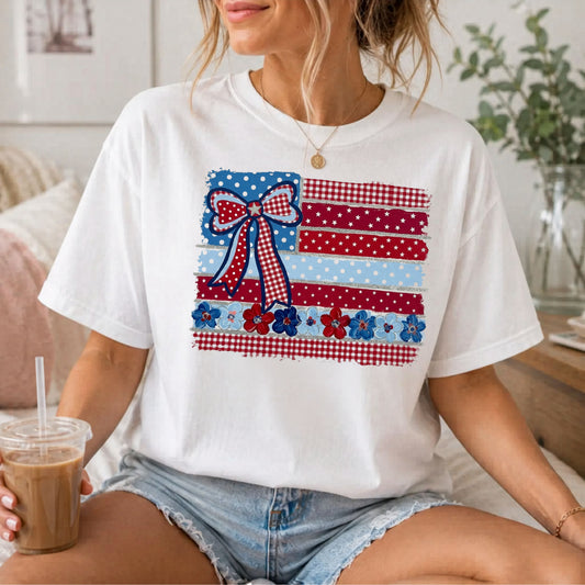 White garment-dyed t-shirt with Americana patchwork flag bow graphic in red, white and blue