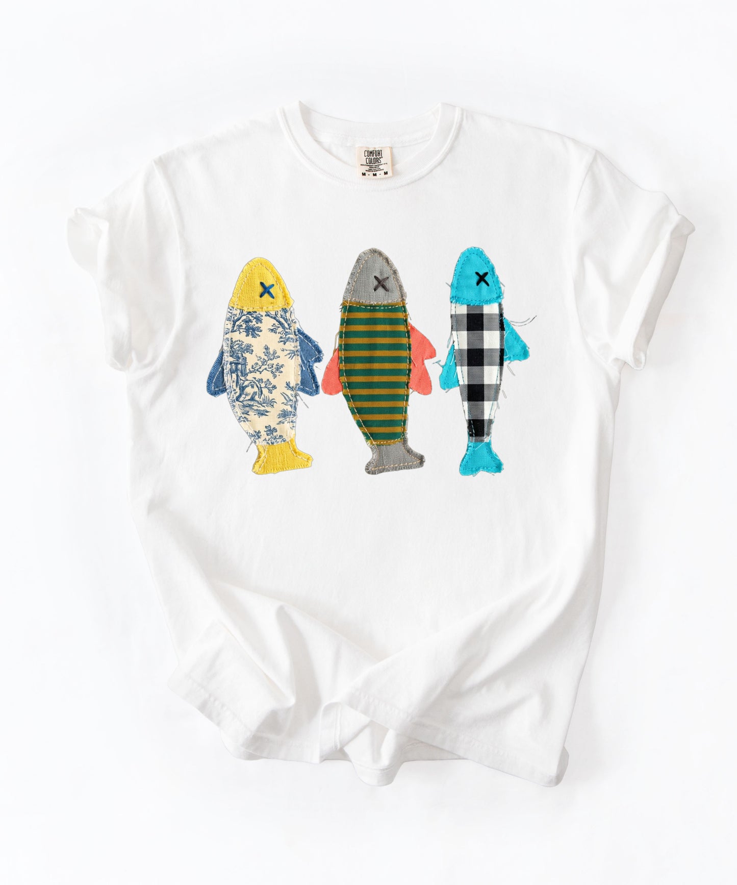 Faux patterned fish trio graphic tee in White featuring three fish in faux floral, faux stripe, and faux buffalo-check prints — front view on garment-dyed cotton