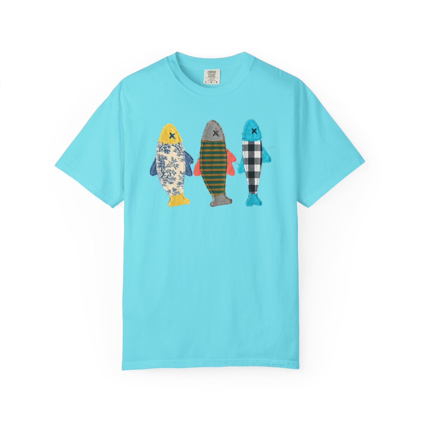 Faux patterned fish trio graphic tee in Lagoon Blue featuring three fish in faux floral, faux stripe, and faux buffalo-check prints — front view on garment-dyed cotton