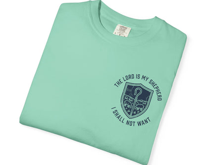 A folded Island Reef t-shirt with a dark navy blue graphic on the front. The graphic features a shepherd's crook inside a shield, surrounded by the text 'THE LORD IS MY SHEPHERD I SHALL NOT WANT'.