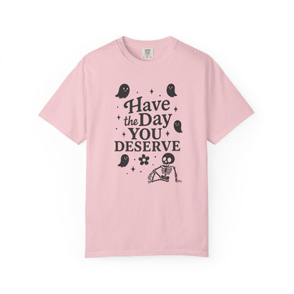 light pink t-shirt with Halloween-themed design and text that says "have the day you deserve" on a white background