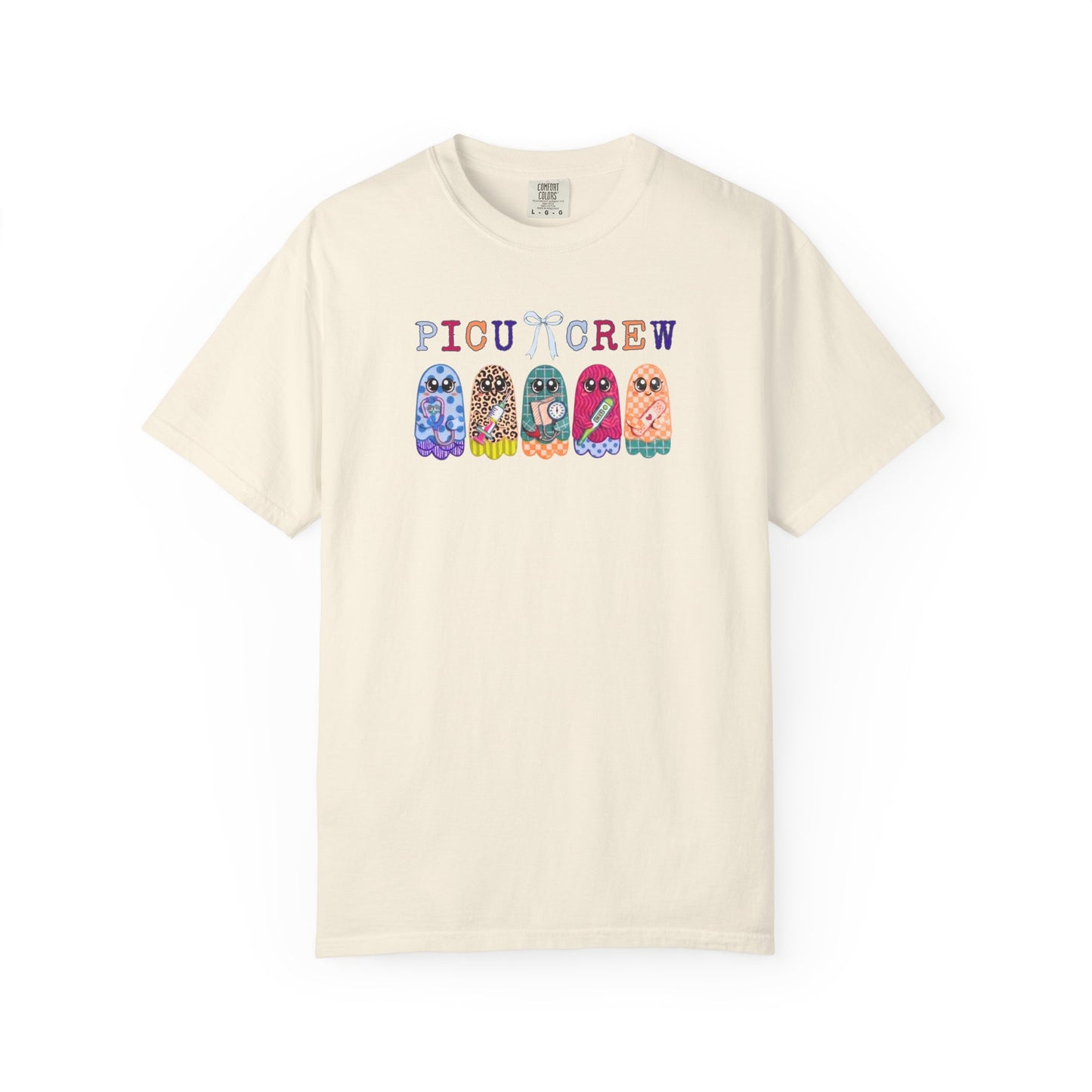 Ivory Comfort Colors PICU Crew t-shirt with five colorful patterned ghosts holding nursing tools — pediatric ICU nurse graphic tee, flat lay