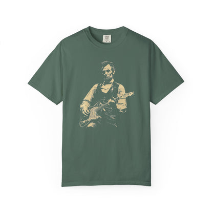 light green  t-shirt with a graphic of a president lincoln  playing guitar on a white background