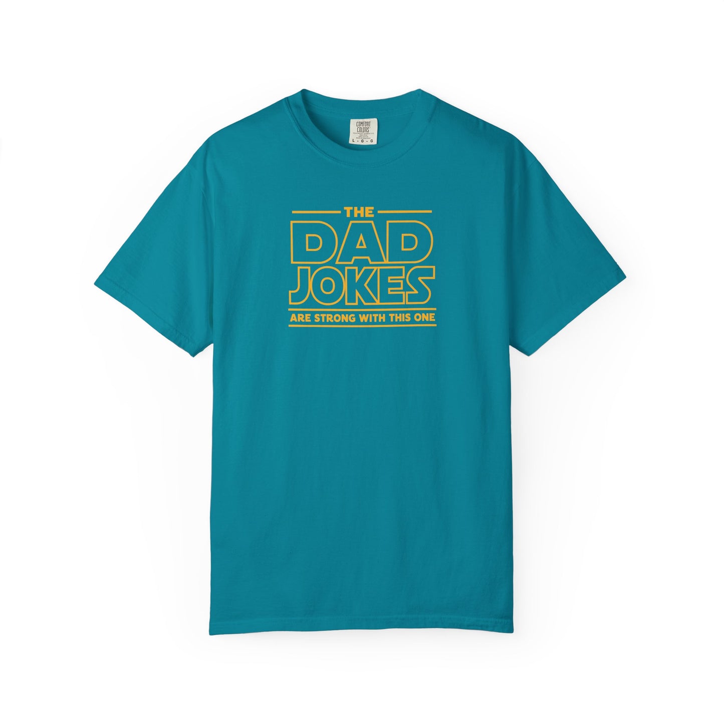 a topaz blue t-shirt with yellow text 'The Dad Jokes Are Strong With This One' in front of a blurred background