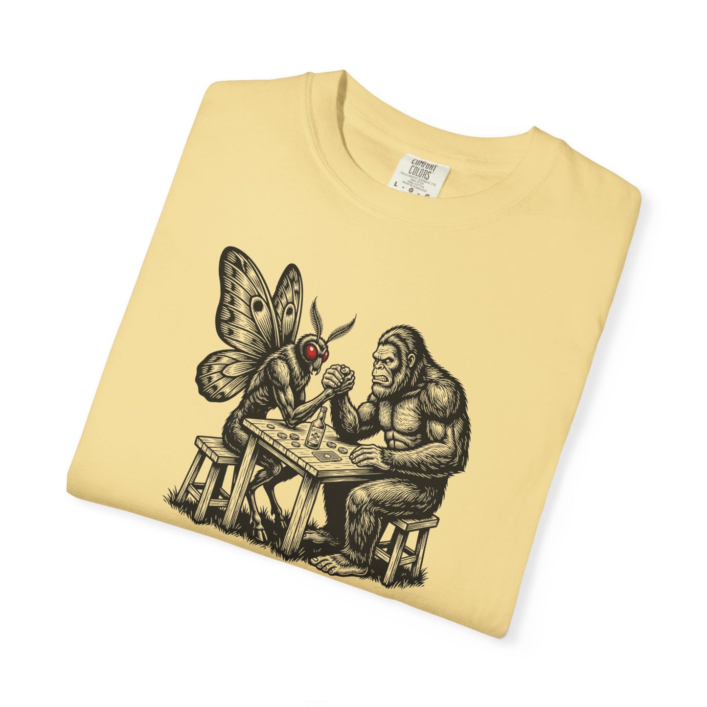 Butter garment-dyed unisex Bigfoot vs Mothman arm wrestling graphic tee — funny cryptid shirt