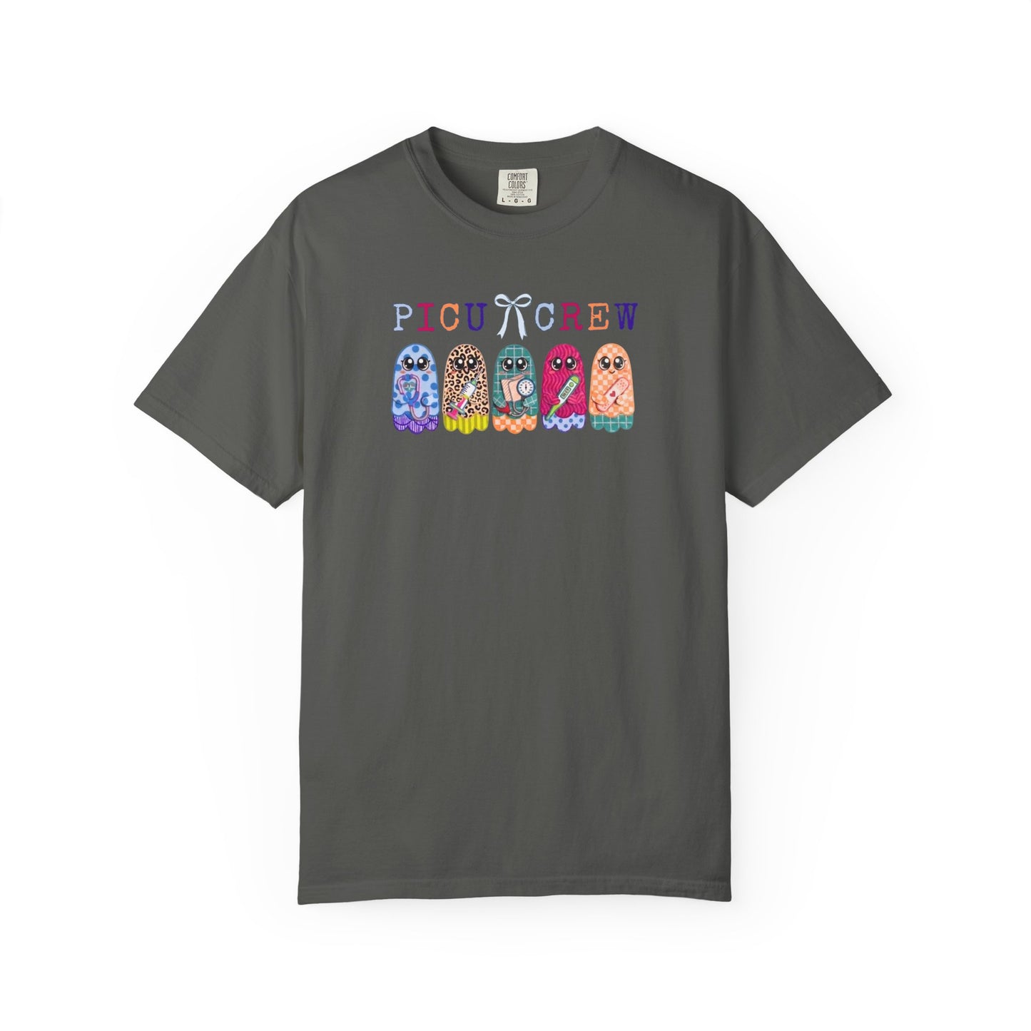 Pepper Comfort Colors PICU Crew t-shirt with five colorful patterned ghosts holding nursing tools — pediatric ICU nurse graphic tee, flat lay