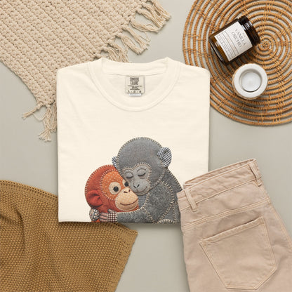 ivory t-shirt with monkey design, beige pants, and decorative items on a light gray surface