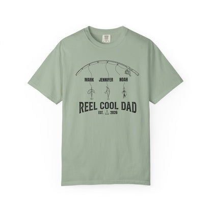 Bay t-shirt with a graphic of a fishing rod and text reel cool dad on a white background