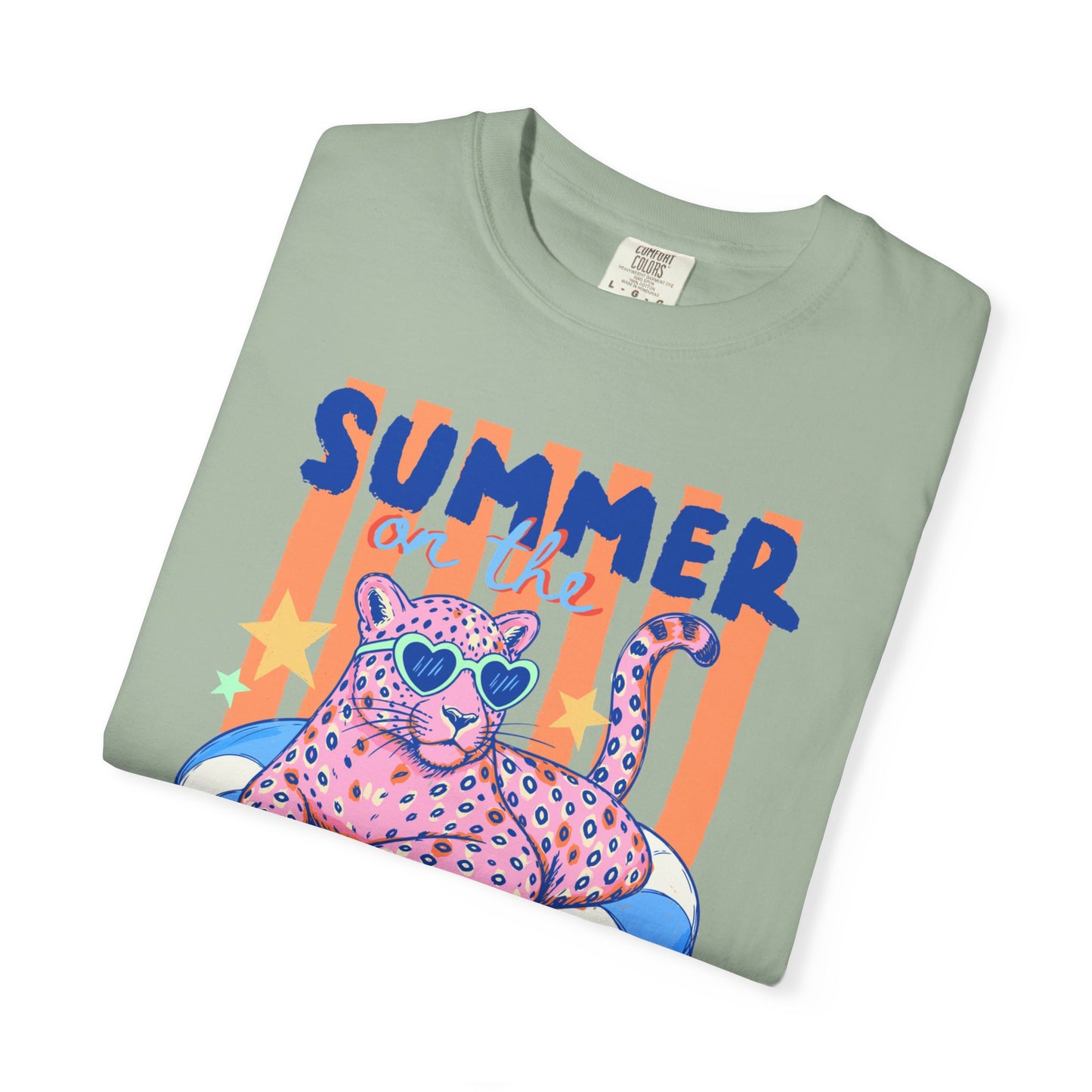 Folded Bay colored t-shirt with a colorful design of a panther and 'Summer on the' text on a light green background.