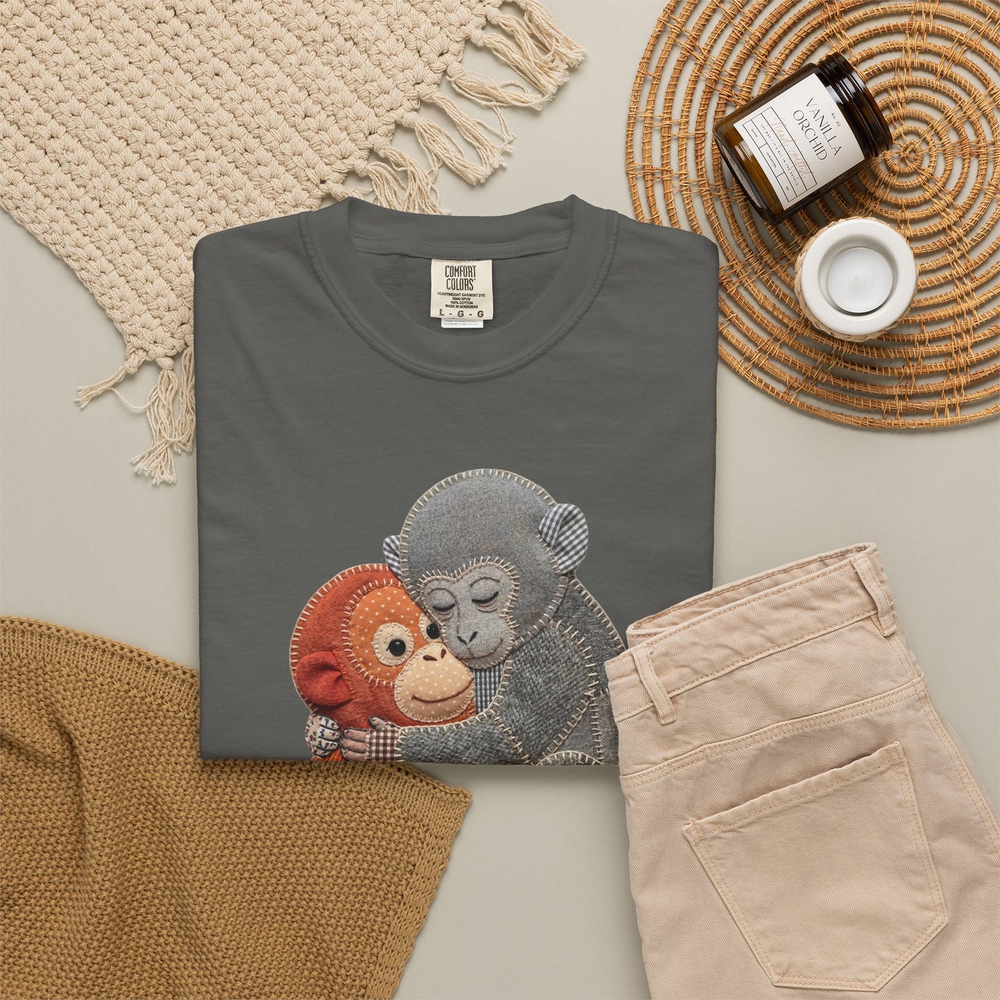 Folded pepper t-shirt with monkey design on a neutral surface with accessories.
