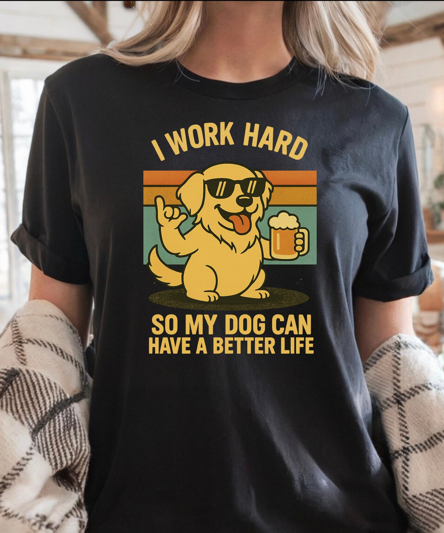 Person wearing a black t-shirt with a graphic of a dog and text that says "i work hard so my dog can have a better life, set indoors.