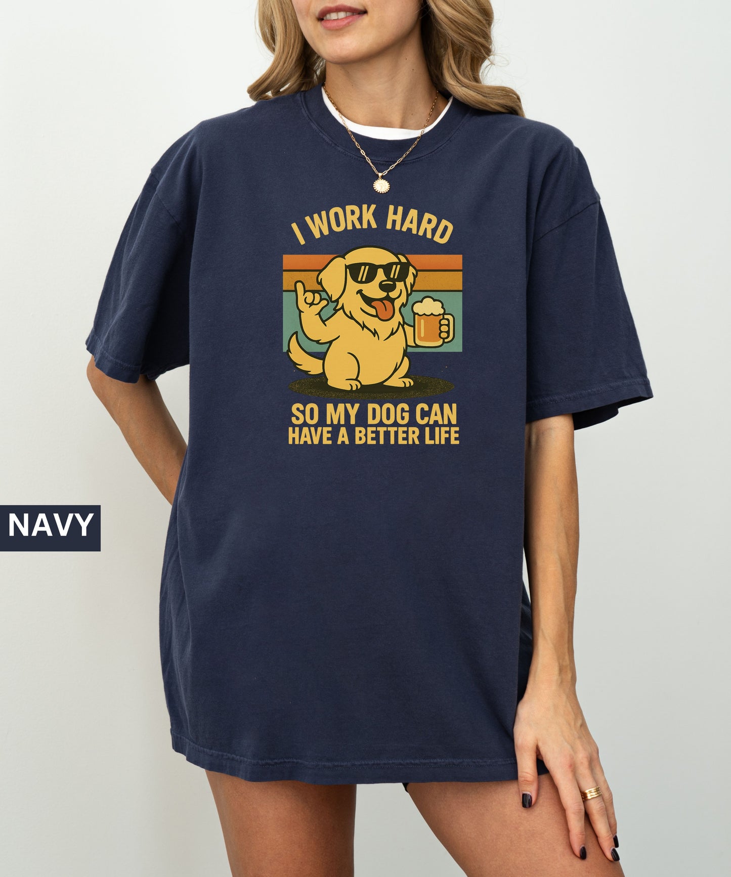 Person wearing a navy t-shirt with a graphic of a dog and text that says "i work hard so my dog can have a better life, set indoors.