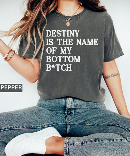 Person wearing a t-shirt with text 'Destiny is the name of my bottom B*tch' on a plain background.