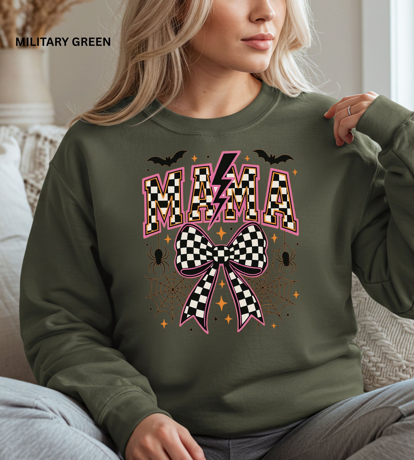 Person wearing a military green sweatshirt with 'MAMA' and checkered bow design.