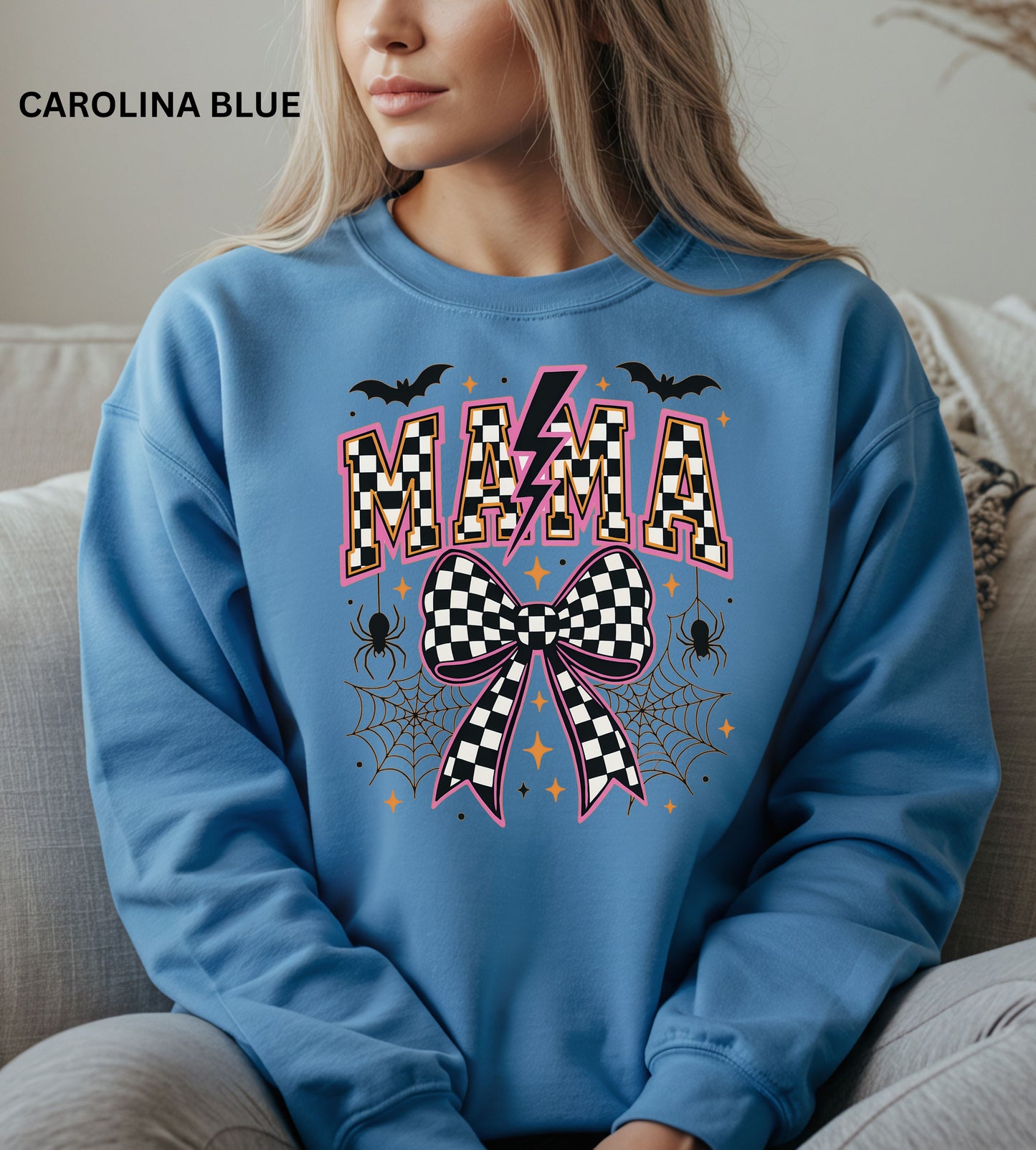 Person wearing a carolina blue sweatshirt with 'MAMA' and checkered bow design.