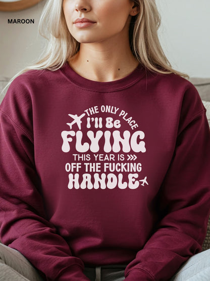 Person wearing a maroon sweatshirt with a humorous text design that says "the only place ill be flying is off the fucking handle, sitting on a couch.