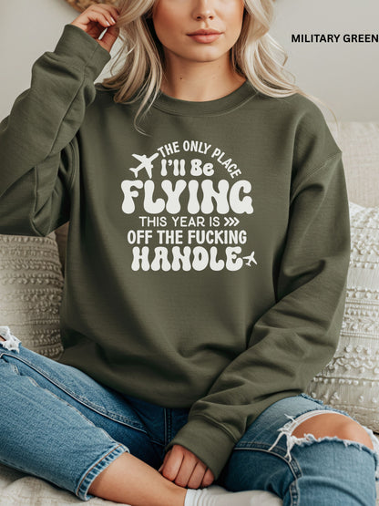 Person wearing a military green sweatshirt with a humorous text design that says "the only place ill be flying is off the fucking handle, sitting on a couch.