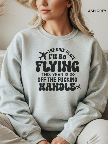 Person wearing an ash grey sweatshirt with a humorous text design that says "the only place ill be flying is off the fucking handle, sitting on a couch.