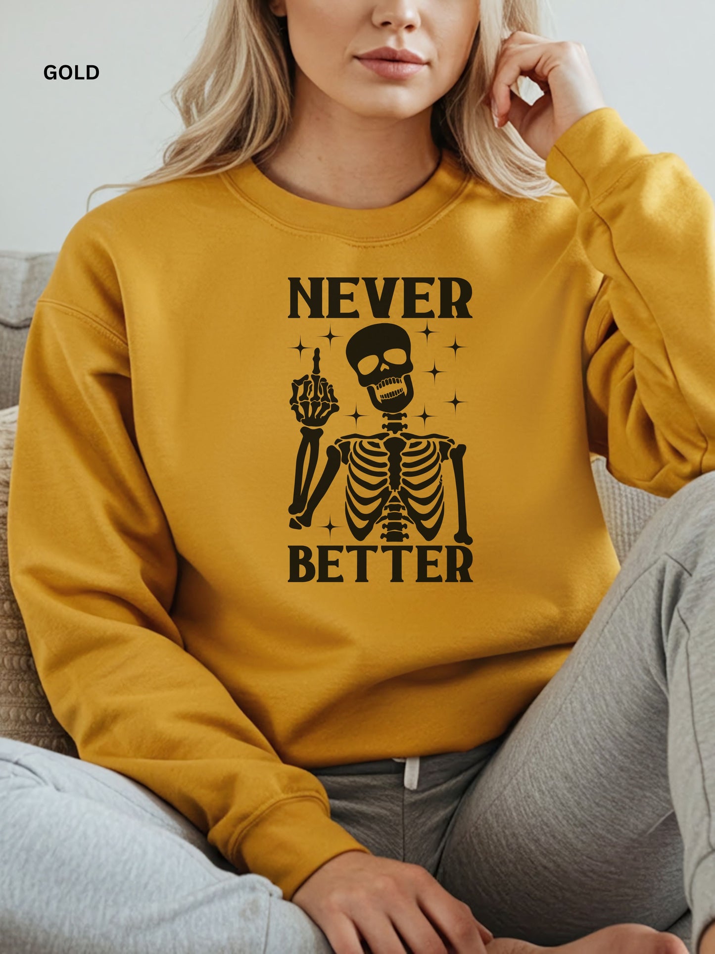 Person wearing a gold sweatshirt with a skeleton graphic and text that says "never better"