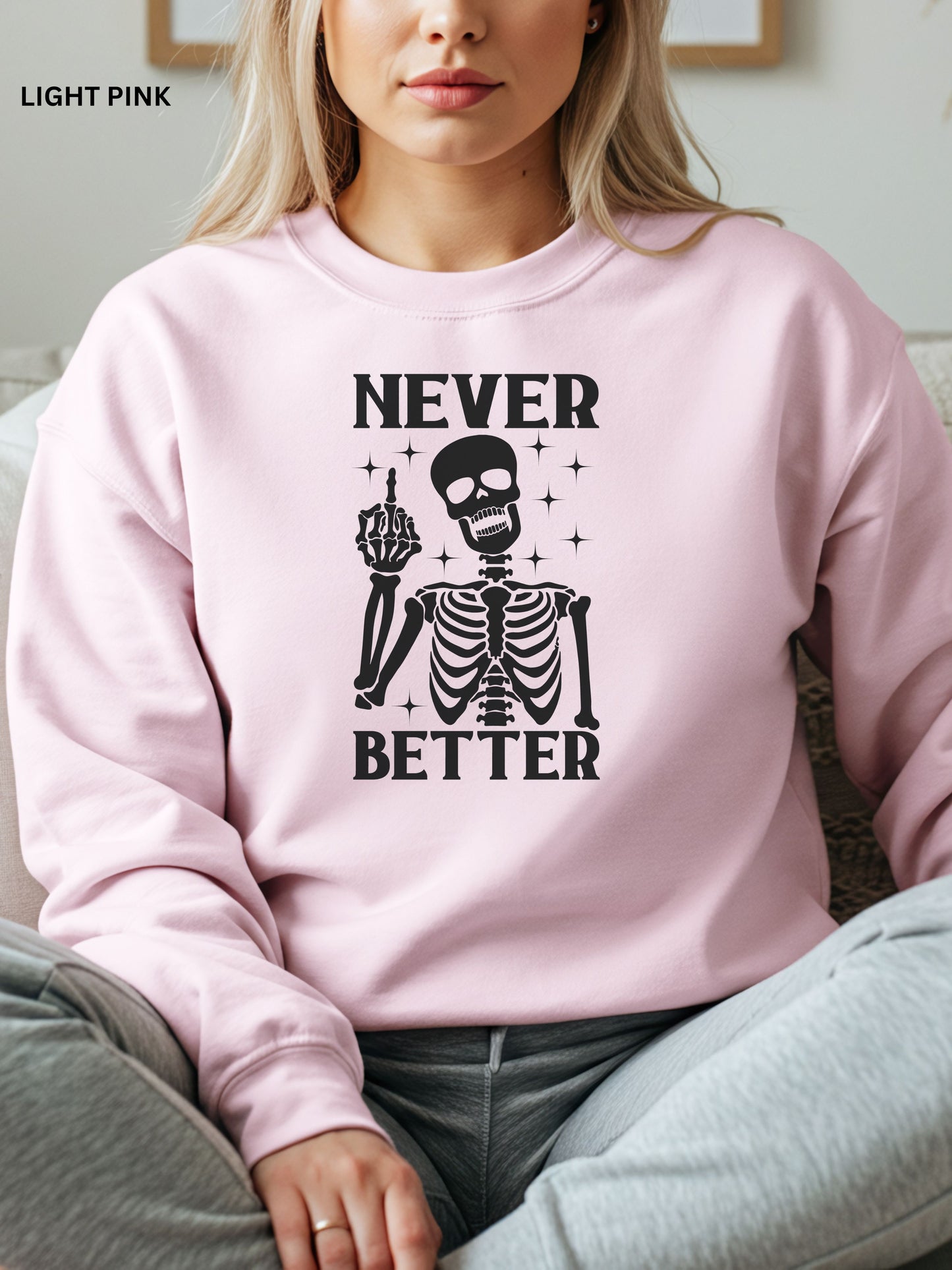 Person wearing a light pink sweatshirt with a skeleton graphic and text that says "never better"