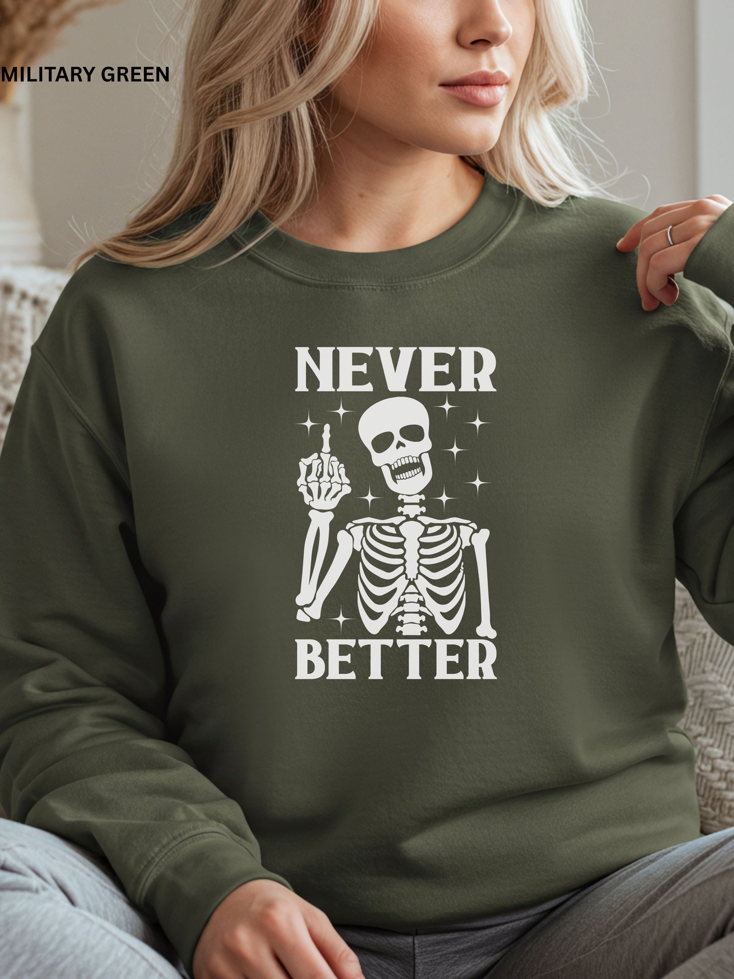 Person wearing a military green sweatshirt with a skeleton graphic and text that says "never better"
