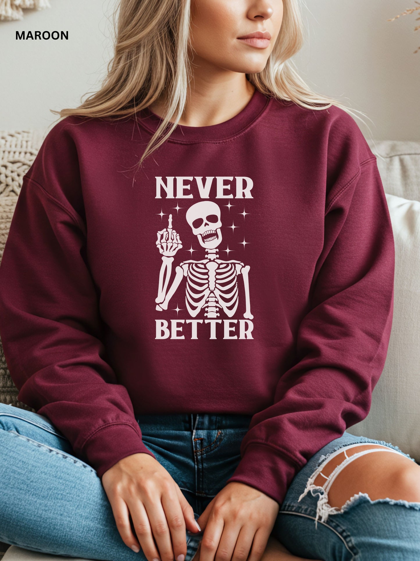 Person wearing a maroon sweatshirt with a skeleton graphic and text that says "never better"