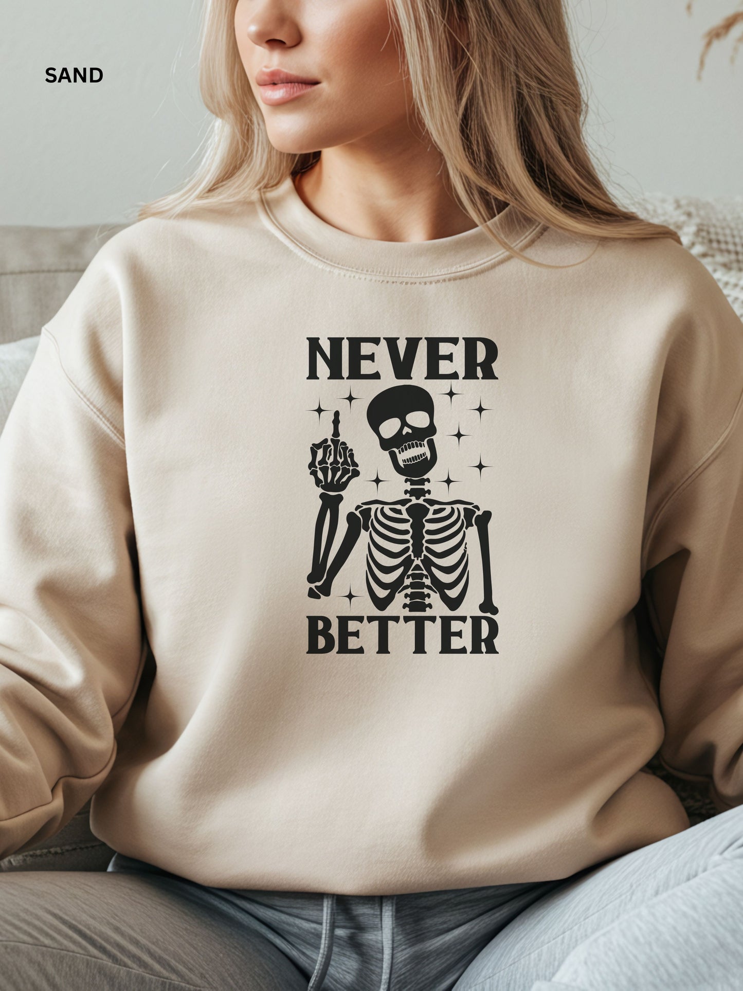 Person wearing a sand sweatshirt with a skeleton graphic and text that says "never better"