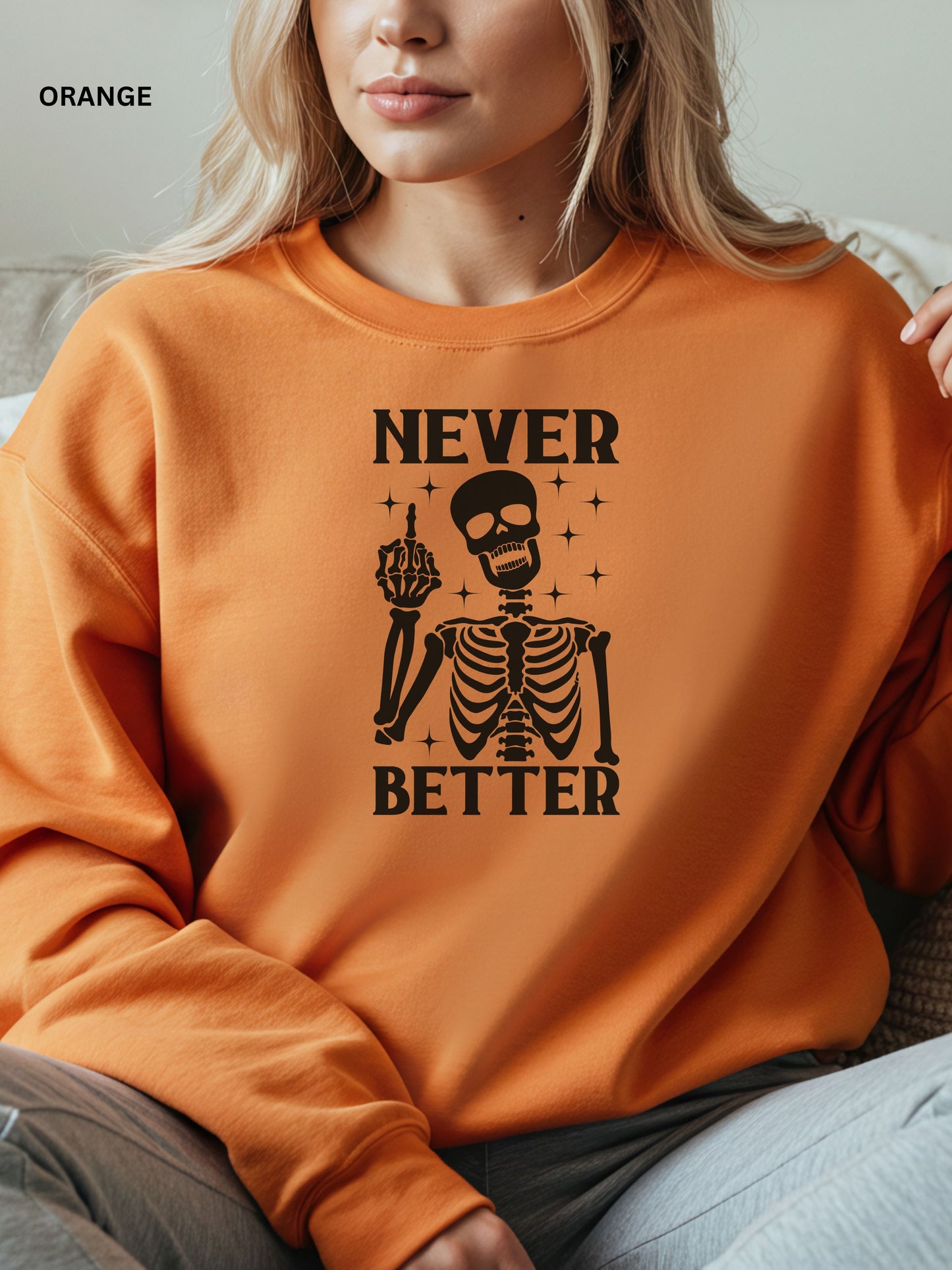Person wearing a orange sweatshirt with a skeleton graphic and text that says "never better"