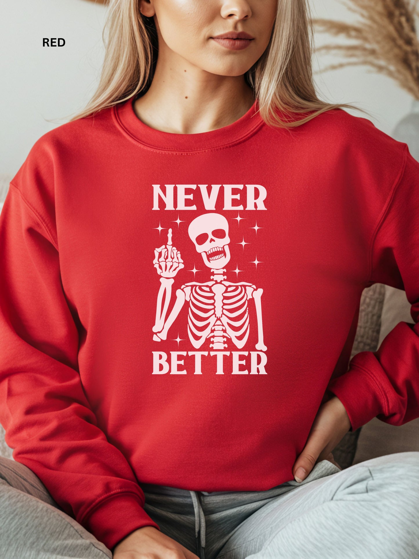 Person wearing a red sweatshirt with a skeleton graphic and text that says "never better"
