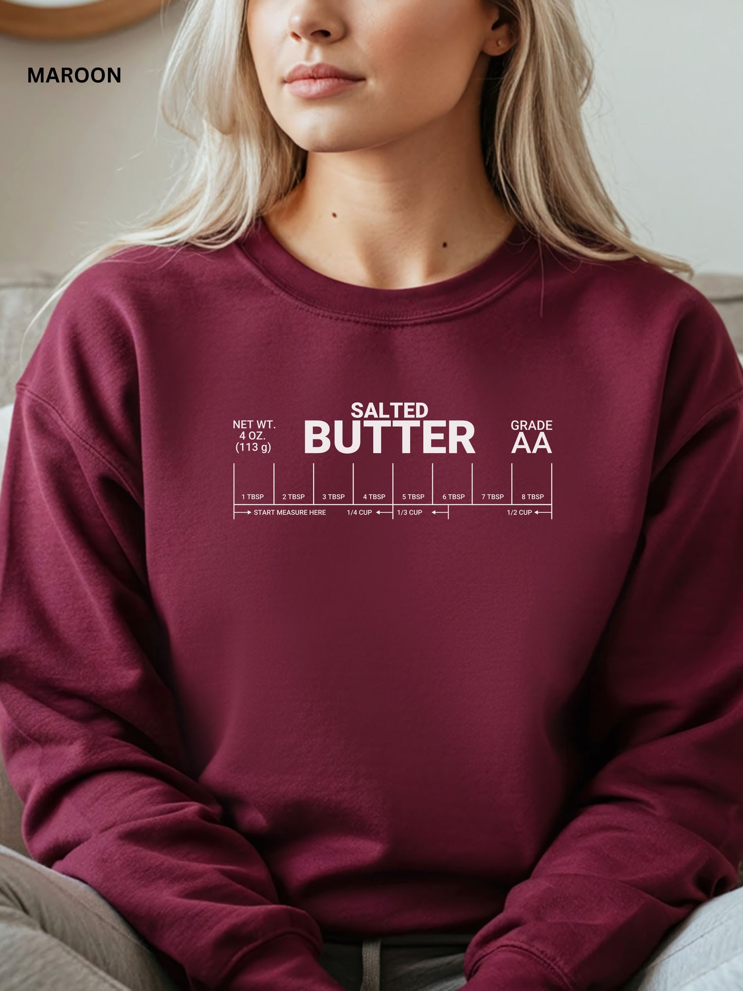 Maroon sweatshirt with 'Salted Butter' text design worn by a person.