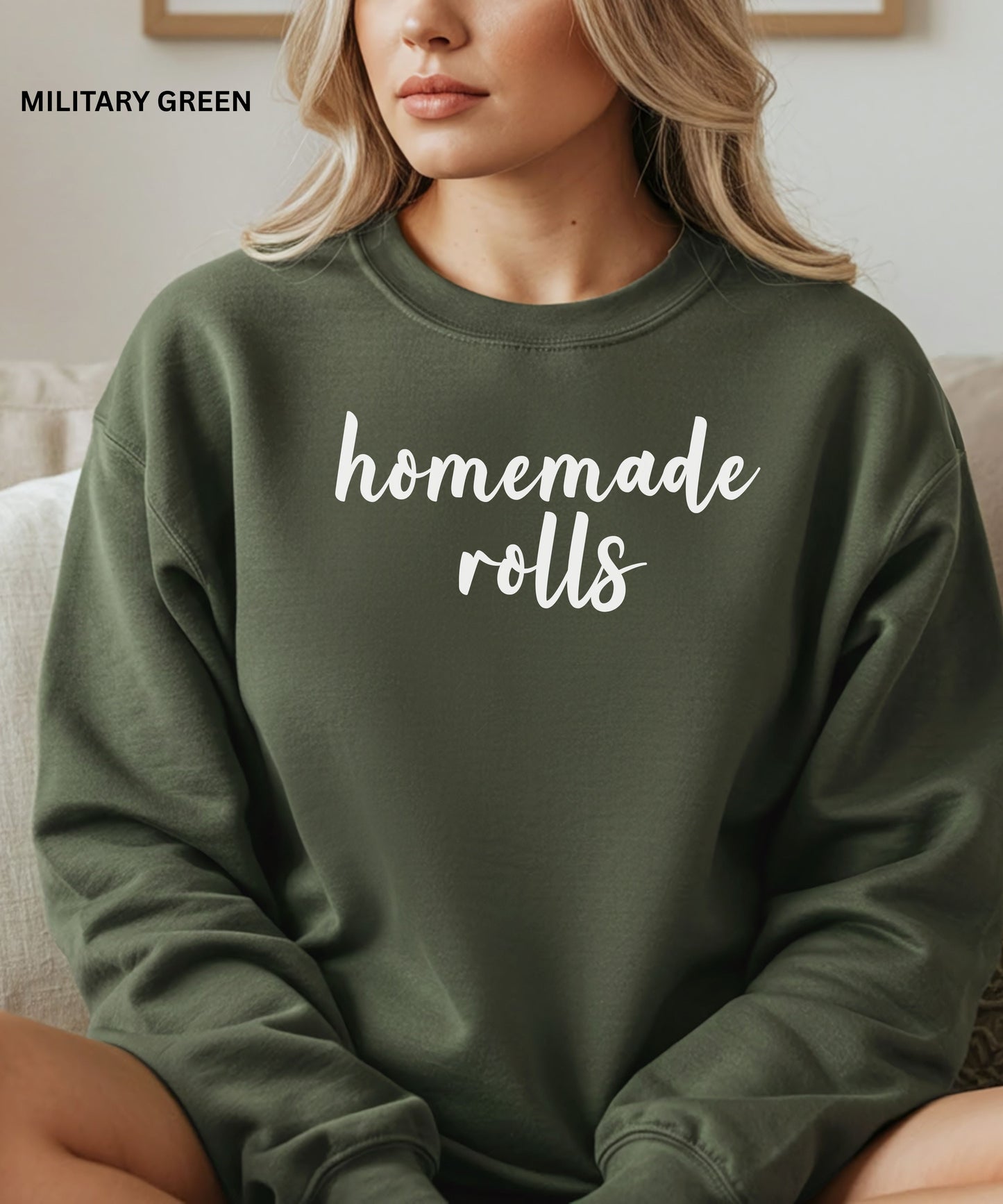 Person wearing a military green sweatshirt with 'homemade rolls' text, sitting on a couch.