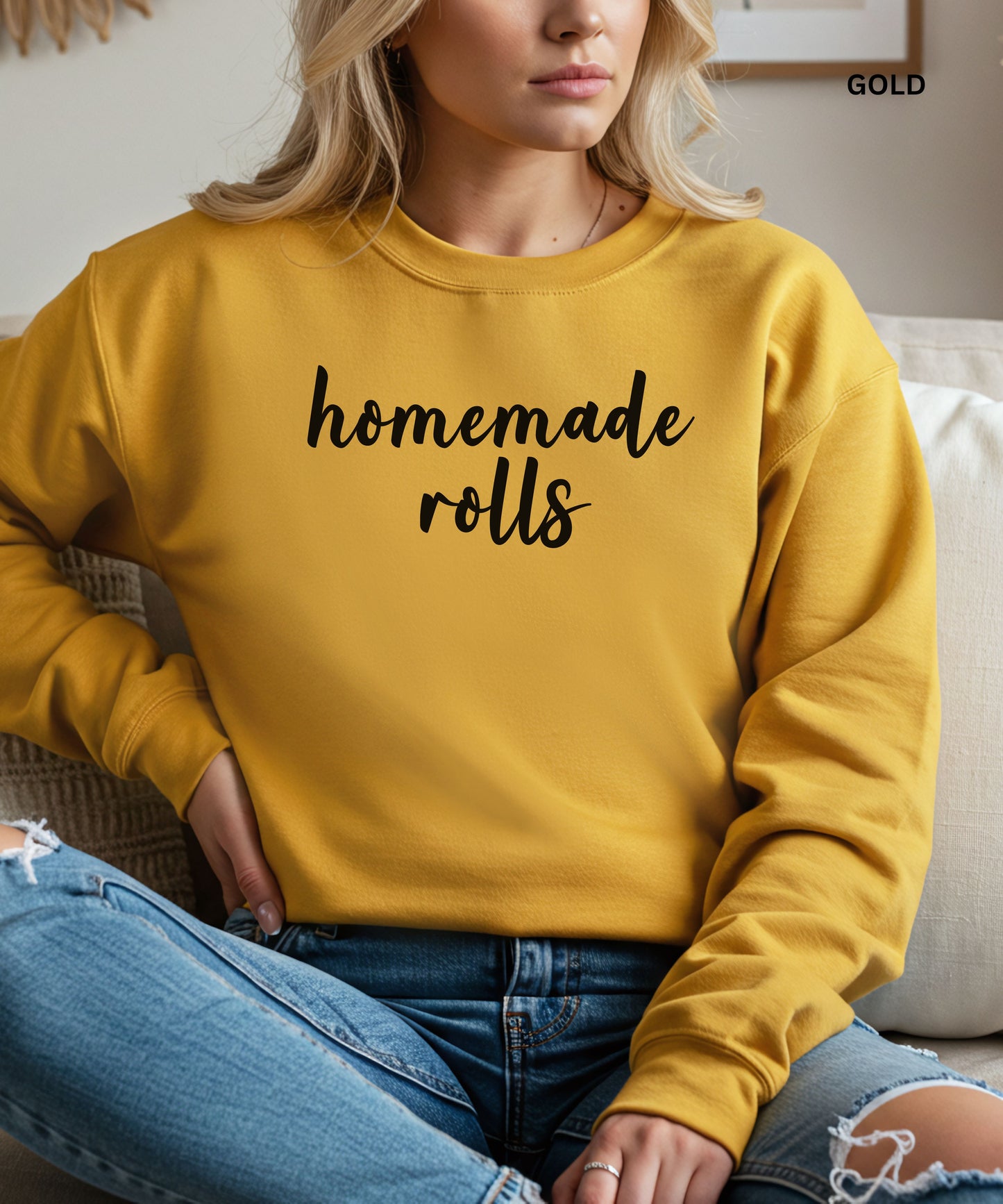 Person wearing a gold sweatshirt with 'homemade rolls' text, sitting on a couch.