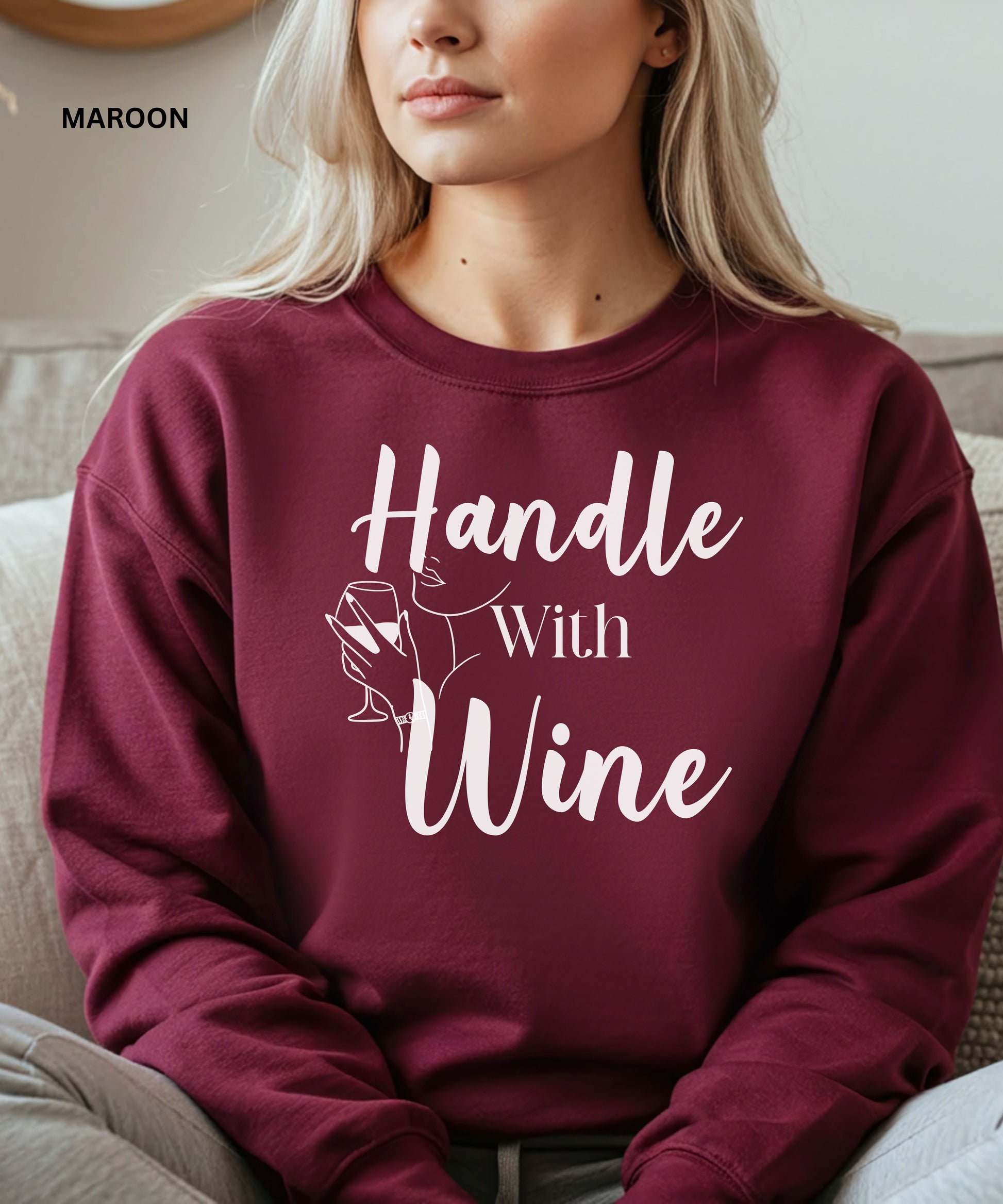 Maroon sweatshirt with 'Handle With Wine' text and graphic, worn by a person.