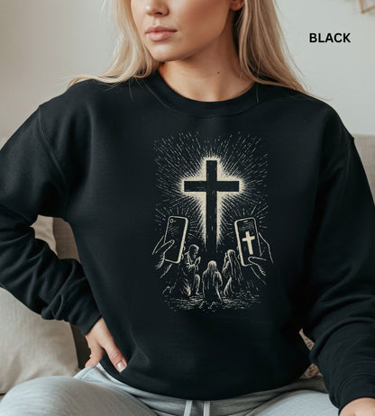 Person wearing a black sweatshirt with a graphic design of hands holding smartphones with crosses on the screens.