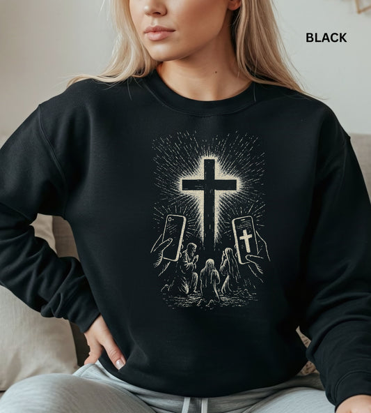 Person wearing a black sweatshirt with a graphic design of hands holding smartphones with crosses on the screens.