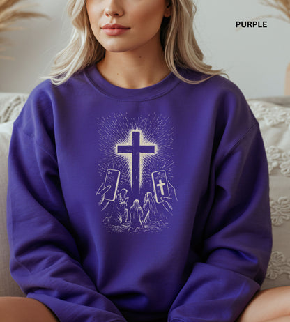 Person wearing a purple sweatshirt with a graphic design of hands holding smartphones with crosses on the screens.


