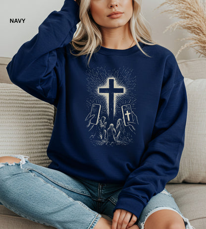 Person wearing a navy sweatshirt with a graphic design of hands holding smartphones with crosses on the screens.

