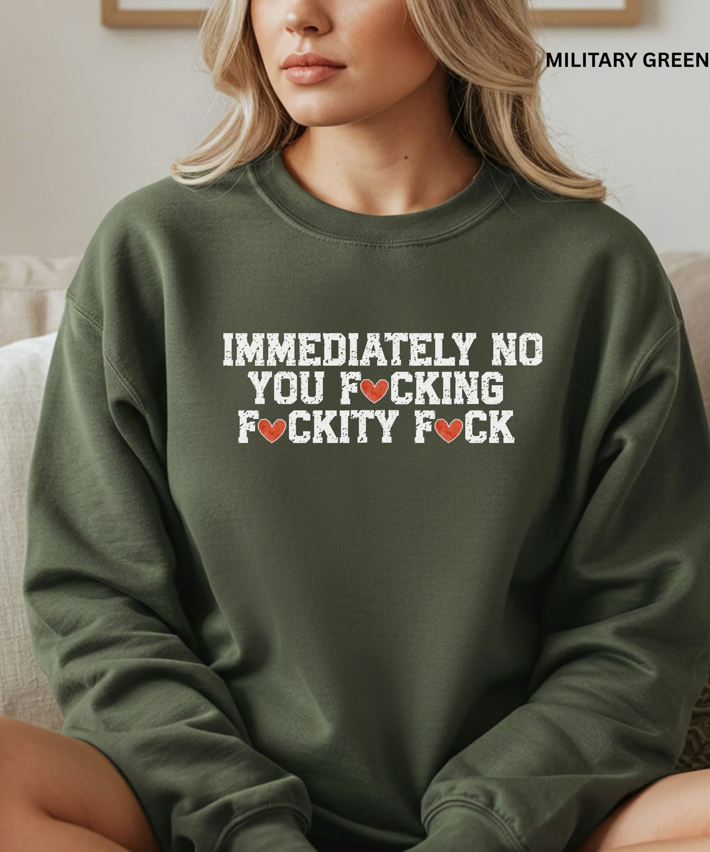 Person wearing a green sweatshirt with offensive language text