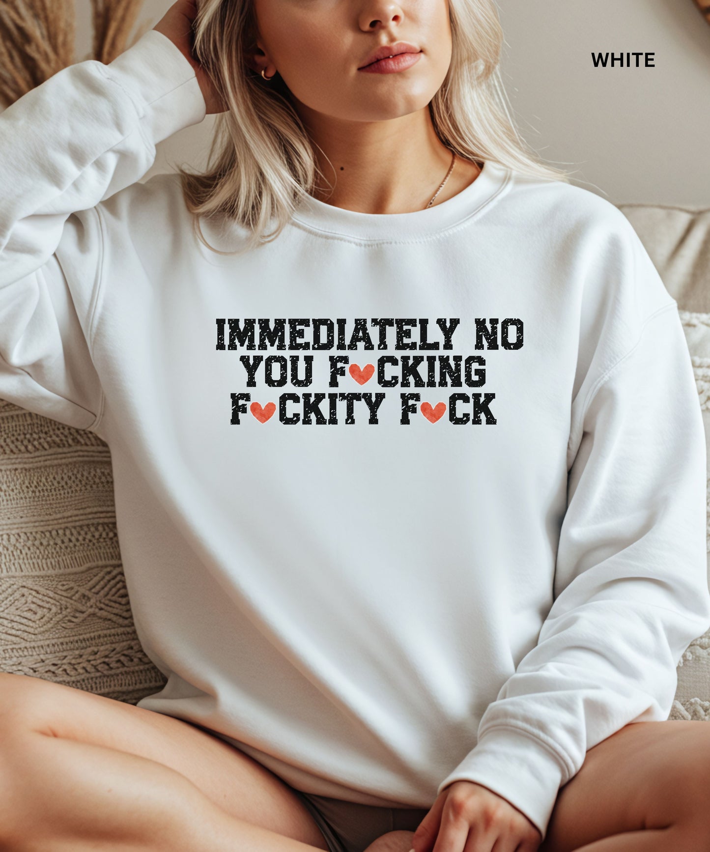 Person wearing a white sweatshirt with a graphic design and text.