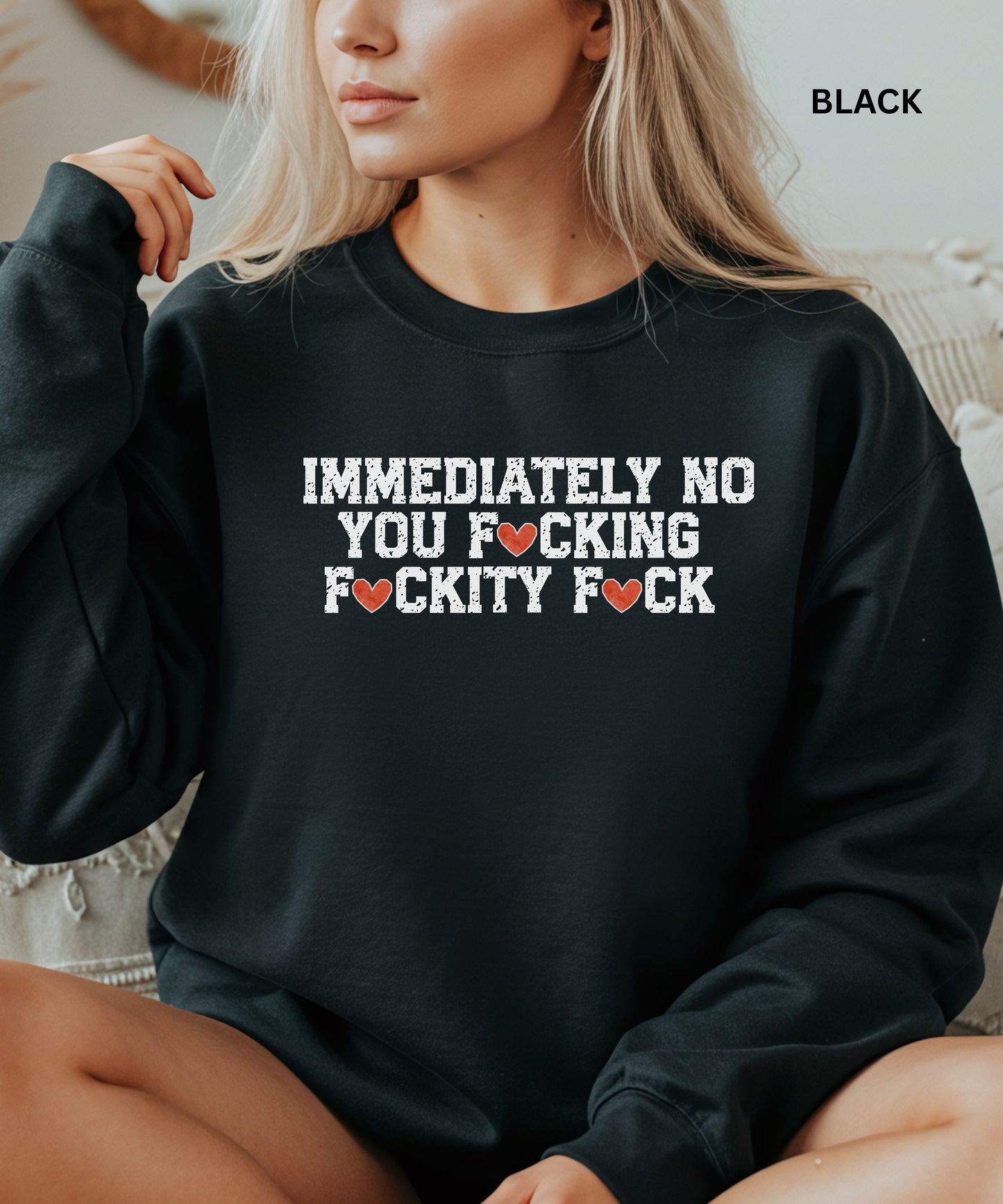 Person wearing a black sweatshirt with a graphic design.