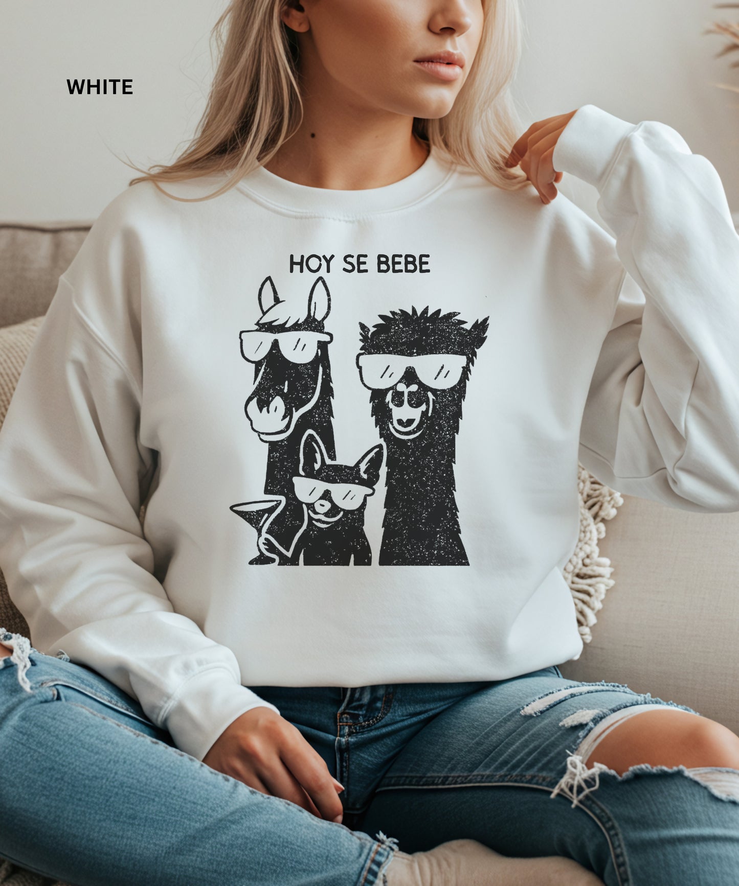 Person wearing a white sweatshirt with llama and dog graphic and 'HOY SE BEBE' text.